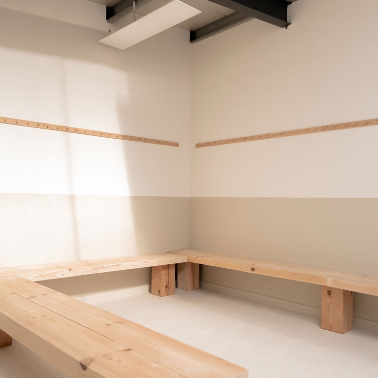Un vestiaire, casiers et banc.
