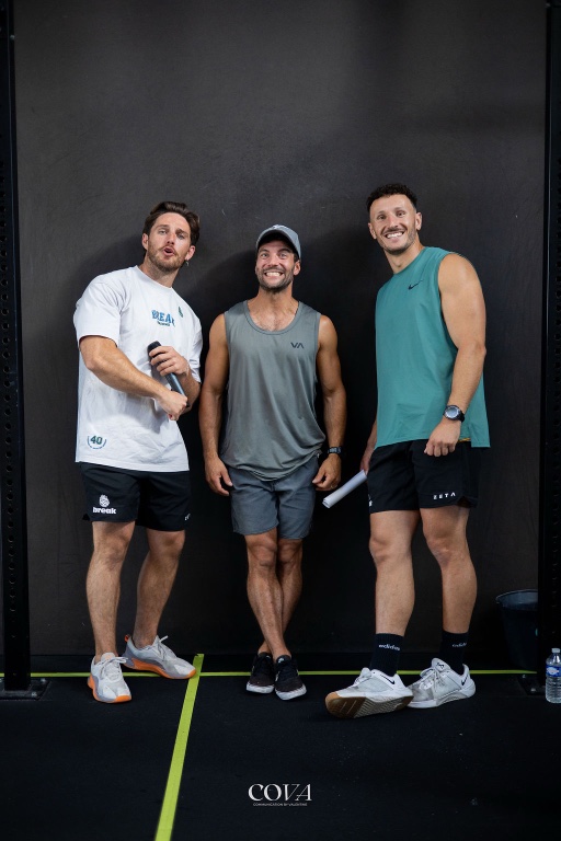 Trois adhérents posent ensemble contre le mur de la box.